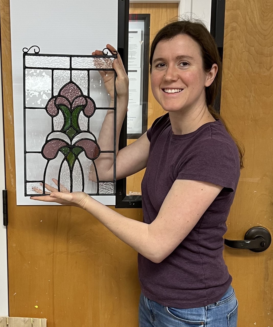 Woman holding stained glass artwork.