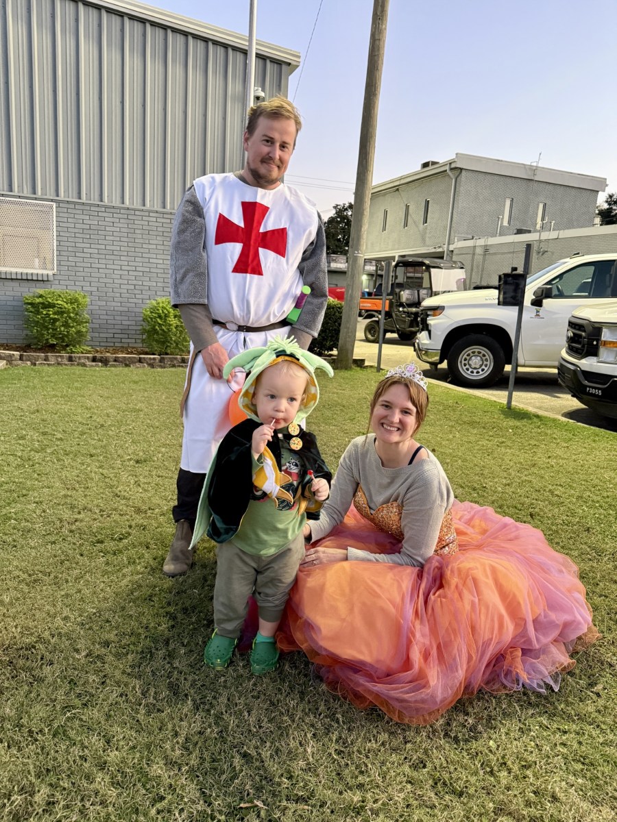 family in halloween costumes standing together