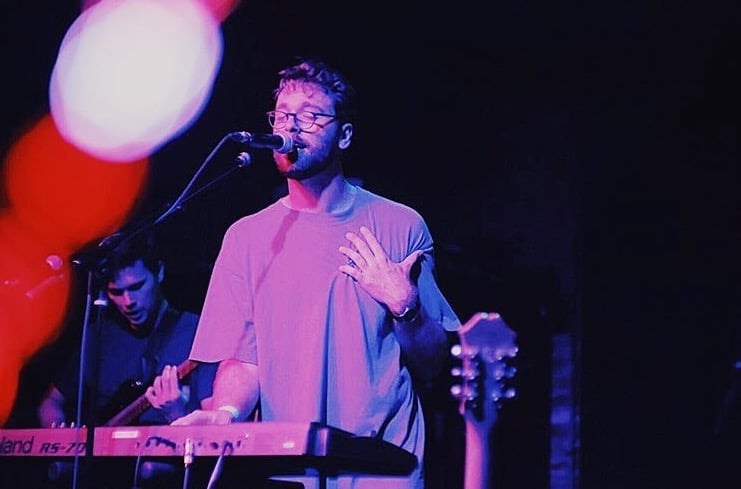 Musician performing on stage with keyboard