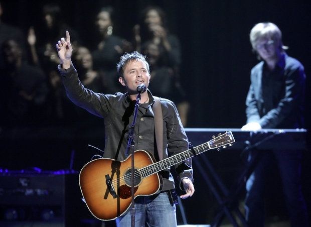 Singer performing with guitar on stage