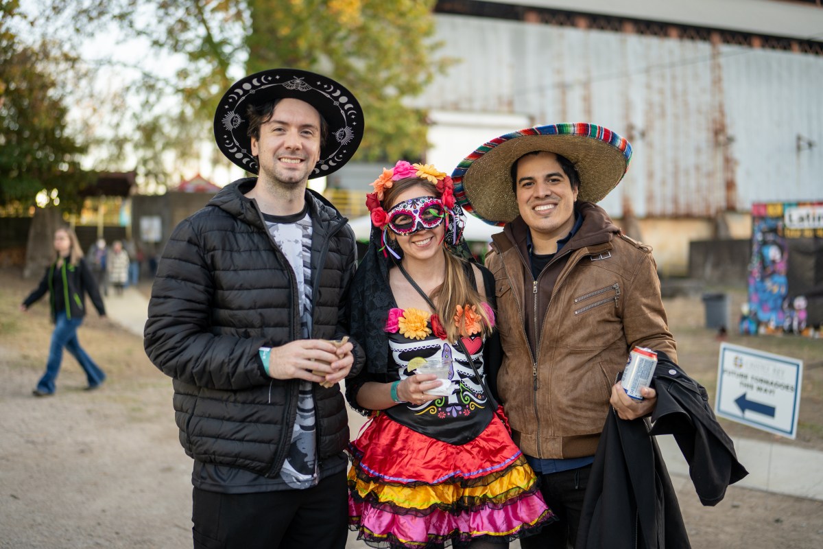 6 ways to celebrate Día de los Muertos in Birmingham 3 Three festivalgoers in hats and sugar skull makeup smile together at Sloss Furnaces' Día de los Muertos festival