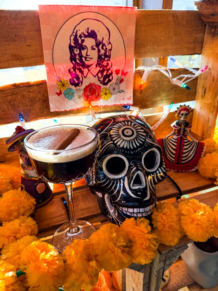6 ways to celebrate Día de los Muertos in Birmingham 6 Wake the Dead cocktail at Mayawell Bar, surrounded by a sugar skull, marigolds and Día de los Muertos decor