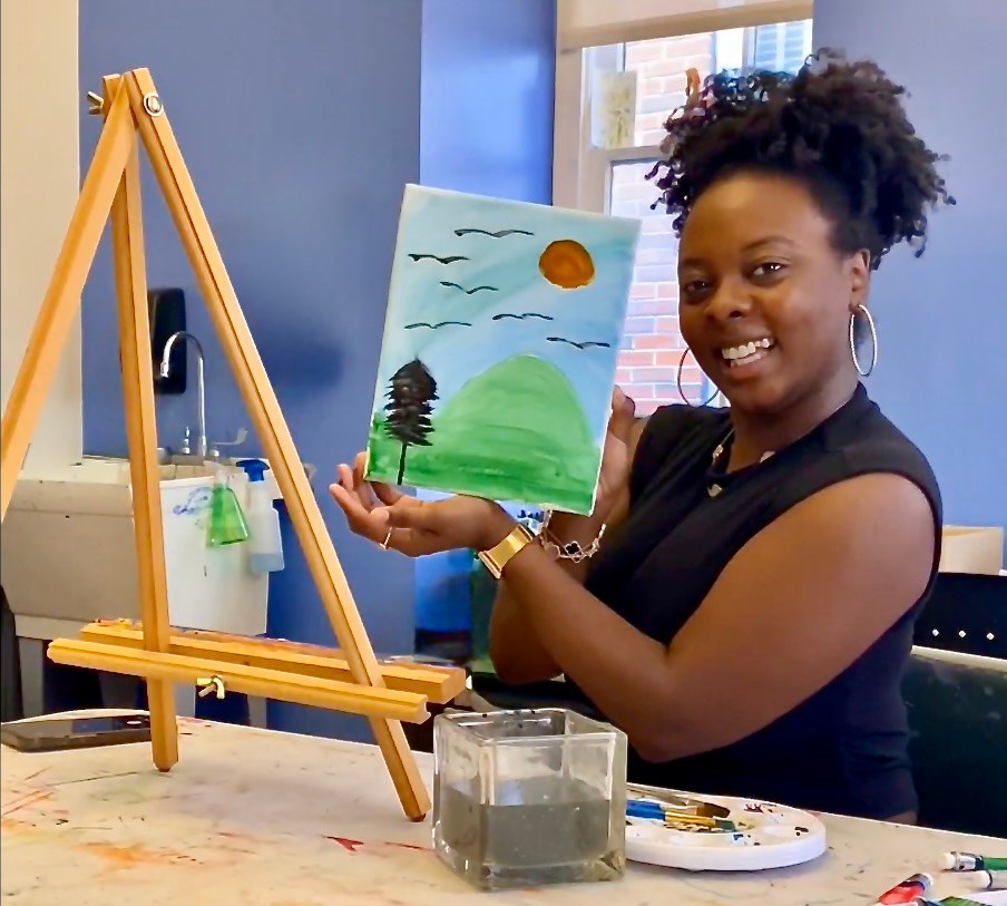 Smiling artist with painted canvas