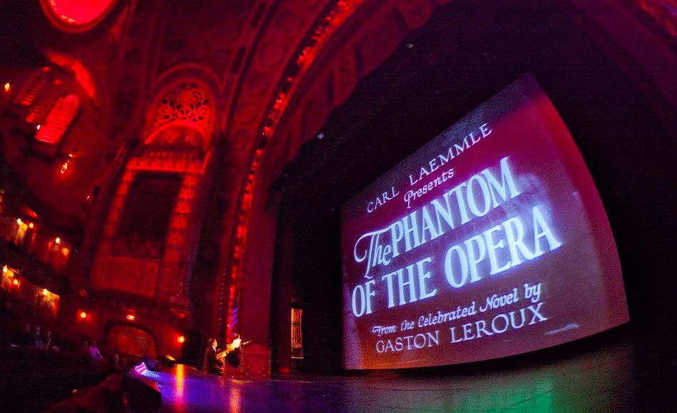 32 family-friendly Halloween events in Birmingham 4 Movie screen in an ornate red-lit theater showing title card: Carl Laemmle Presents The Phantom of the Opera, from the celebrated novel by Gaston Leroux
